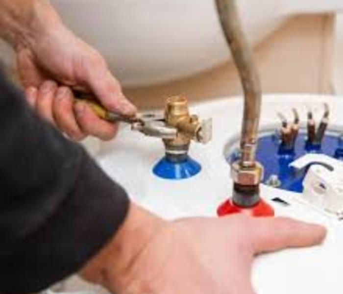 person repairing a water heater